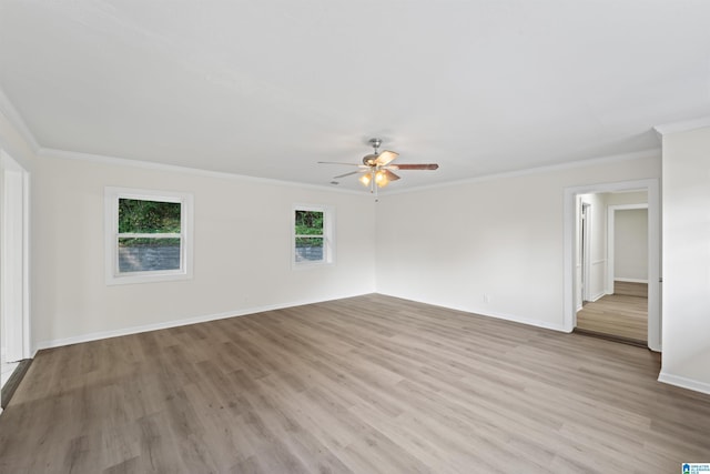 empty room with a ceiling fan, baseboards, crown molding, and light wood finished floors