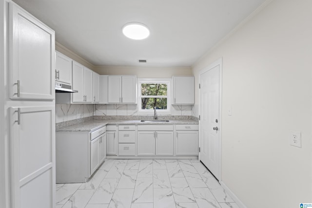 kitchen with marble finish floor, light countertops, white cabinets, a sink, and under cabinet range hood