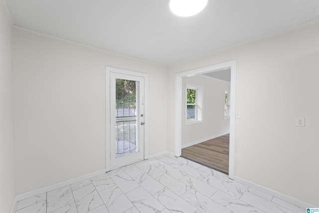 unfurnished room with marble finish floor, ornamental molding, and baseboards