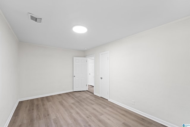 empty room with baseboards, visible vents, and wood finished floors