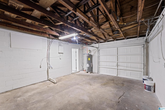 garage featuring water heater and concrete block wall