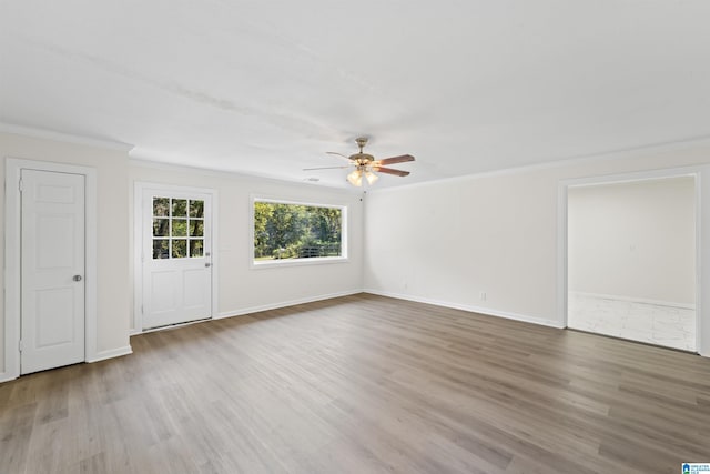 interior space featuring ornamental molding, wood finished floors, and baseboards