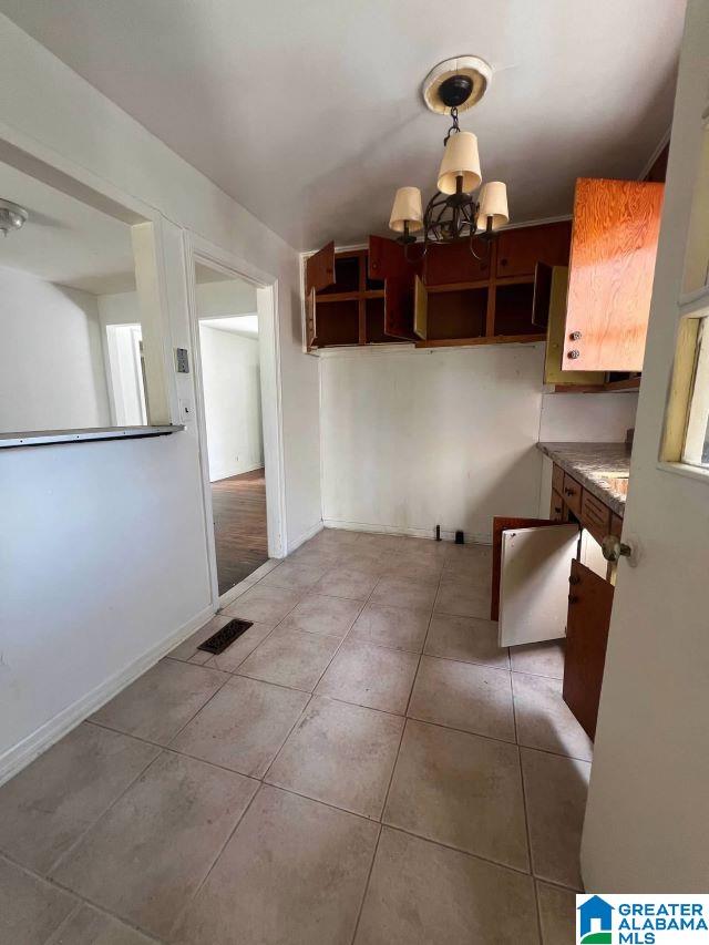 kitchen featuring baseboards, visible vents, an inviting chandelier, and light tile patterned floors