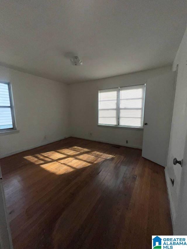 unfurnished room with hardwood / wood-style flooring and a healthy amount of sunlight