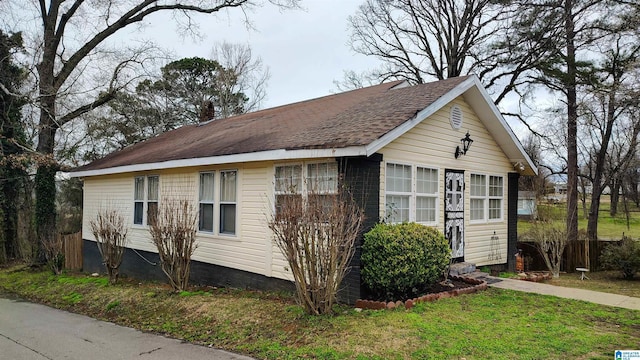 view of side of home featuring a chimney and a yard