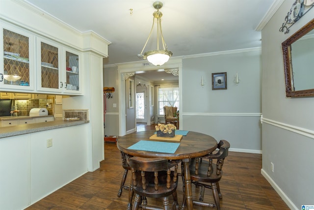 dining space featuring baseboards and crown molding