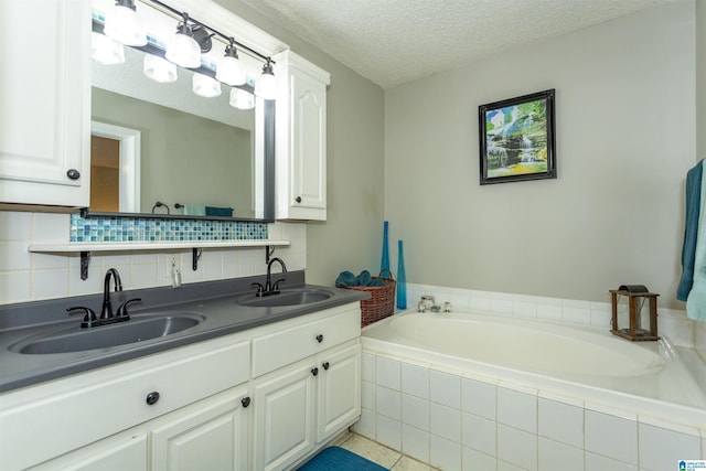 full bathroom featuring a bath, a textured ceiling, backsplash, and a sink