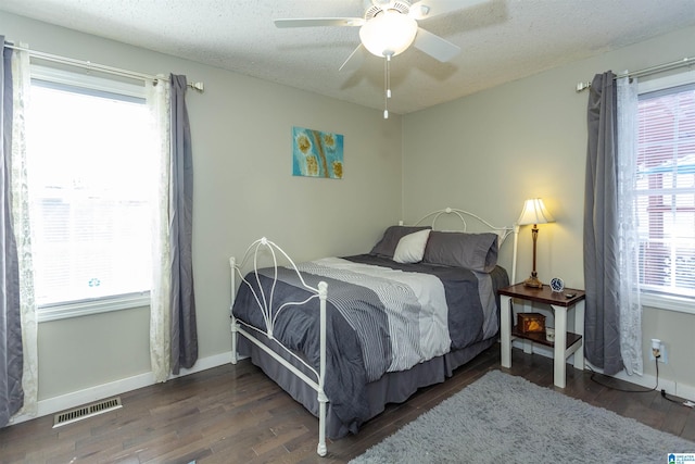 bedroom featuring a textured ceiling, wood finished floors, visible vents, and baseboards