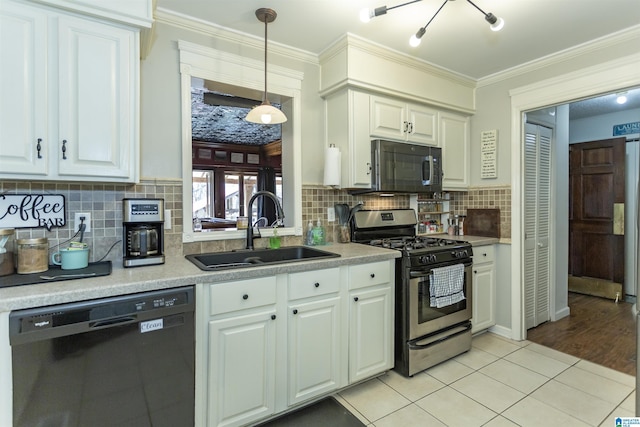 kitchen featuring a sink, light countertops, ornamental molding, black appliances, and decorative light fixtures