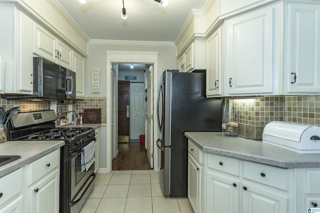 kitchen featuring light tile patterned floors, white cabinets, stainless steel appliances, crown molding, and light countertops