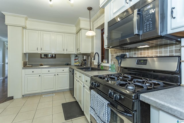 kitchen featuring decorative backsplash, range with gas stovetop, light countertops, a sink, and light tile patterned flooring