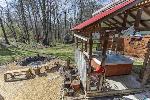 exterior space featuring an outdoor fire pit and a hot tub