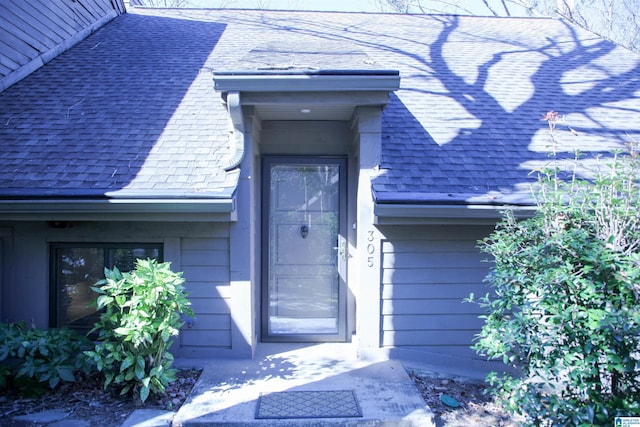 entrance to property with roof with shingles