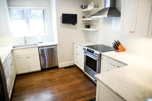 kitchen with dark wood-style floors, appliances with stainless steel finishes, wall chimney range hood, open shelves, and a sink