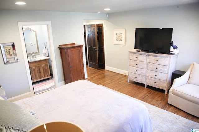 bedroom featuring recessed lighting, connected bathroom, baseboards, and wood finished floors