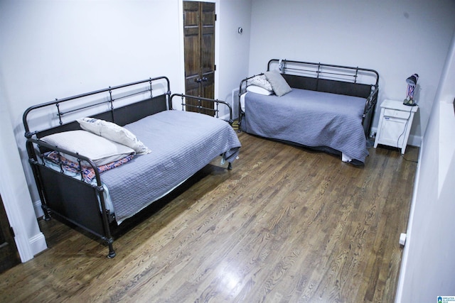 bedroom featuring baseboards and wood finished floors