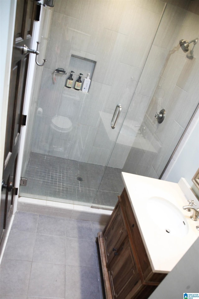 full bathroom with a stall shower, tile patterned flooring, and vanity