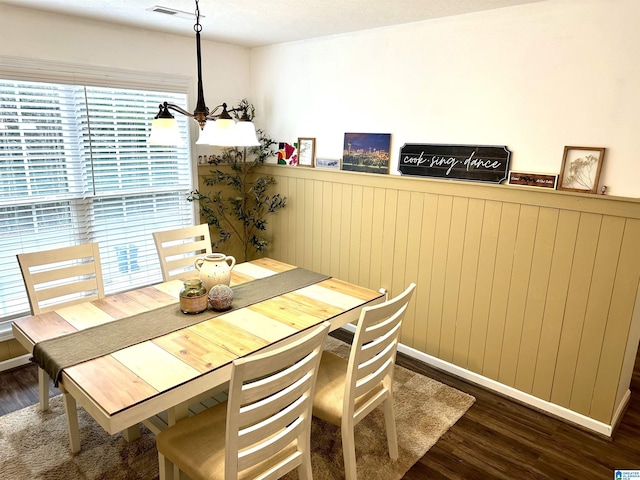 dining room featuring dark wood-style floors and a wainscoted wall
