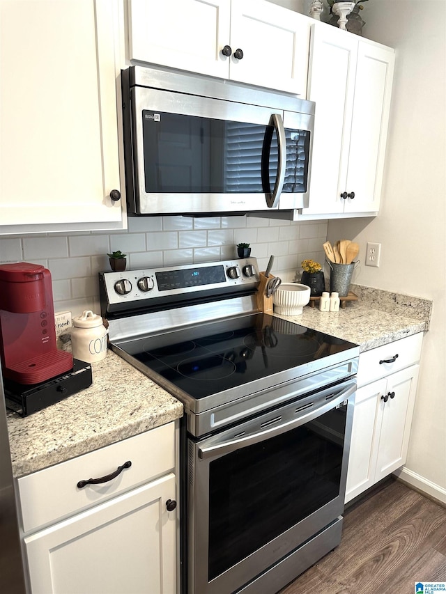 kitchen featuring white cabinets, backsplash, dark wood-style floors, and appliances with stainless steel finishes