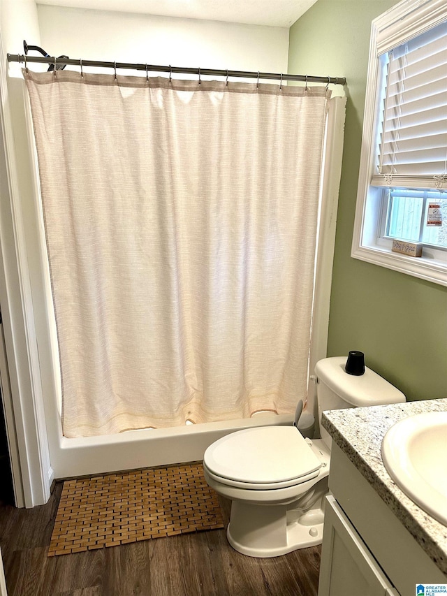 full bathroom featuring curtained shower, toilet, wood finished floors, and vanity