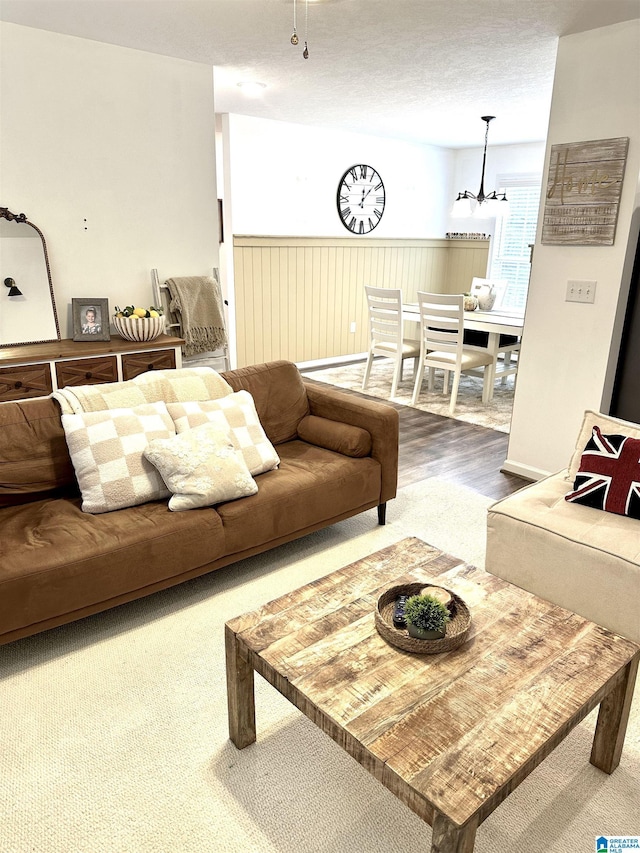 living area with wood finished floors, a wainscoted wall, and a chandelier