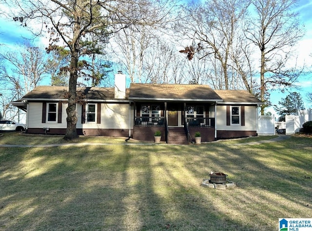 ranch-style house with a chimney, a fire pit, a front lawn, and a porch