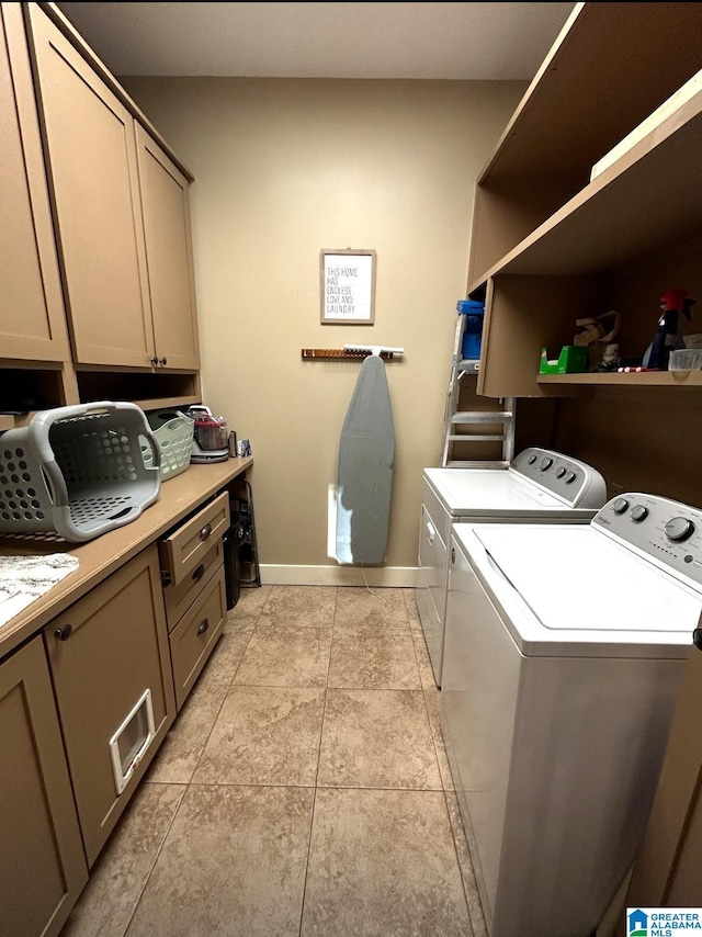 clothes washing area with cabinet space, washer and clothes dryer, baseboards, and light tile patterned floors