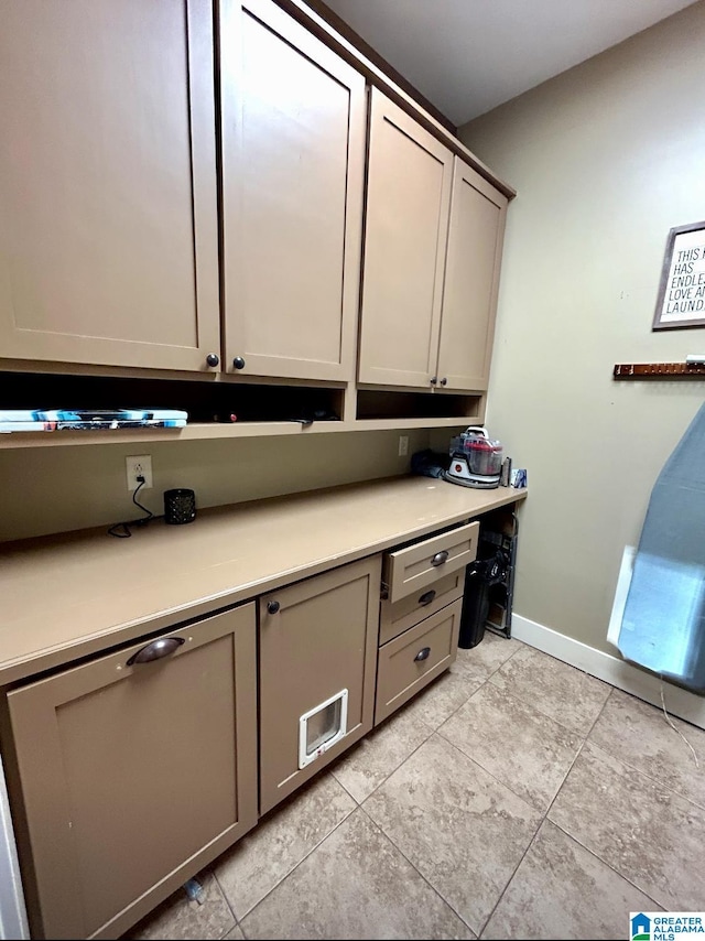 unfurnished office featuring light tile patterned floors and baseboards