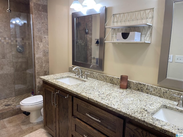 full bathroom with a sink, a shower stall, toilet, and double vanity