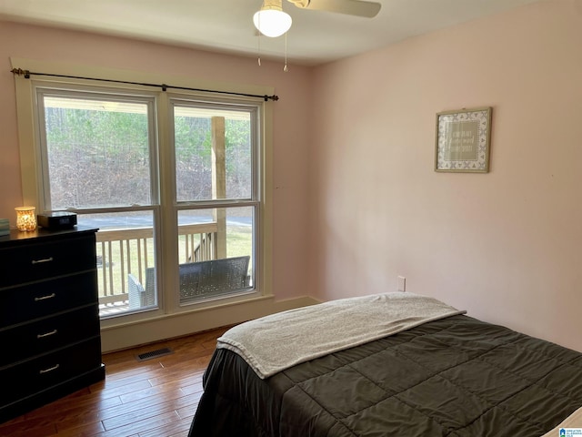 bedroom with dark wood-style floors and visible vents