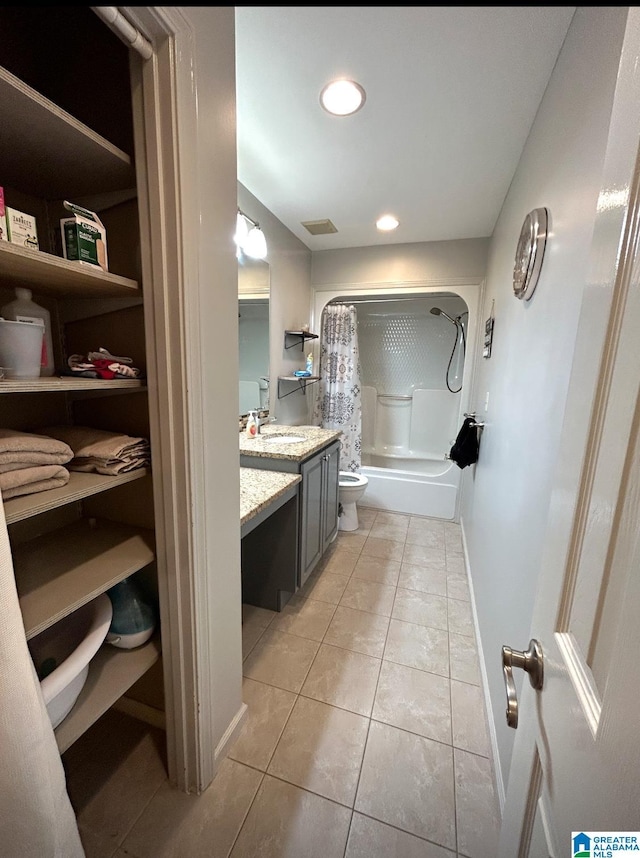 full bathroom featuring toilet, vanity, baseboards, tile patterned floors, and shower / bath combo