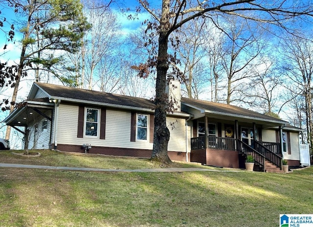 single story home featuring covered porch, a chimney, and a front lawn