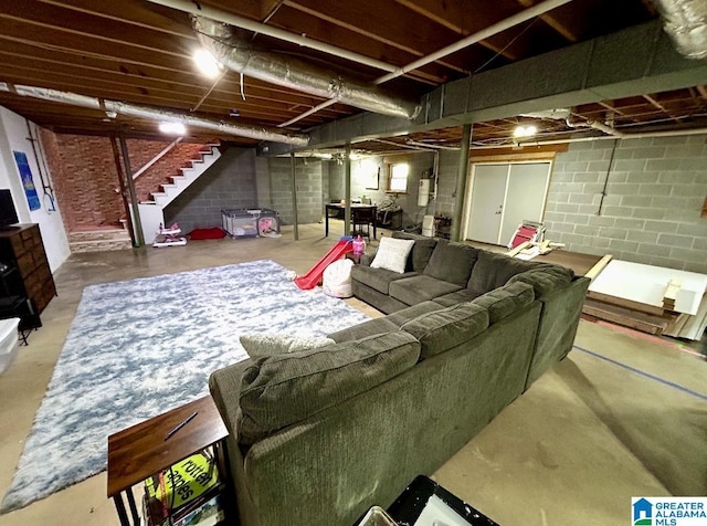 living room with concrete floors, stairway, and electric panel