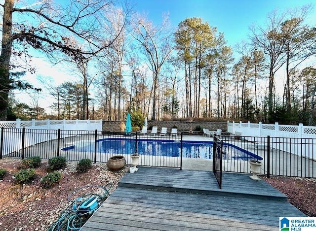 view of swimming pool with a fenced backyard, a fenced in pool, and a wooden deck