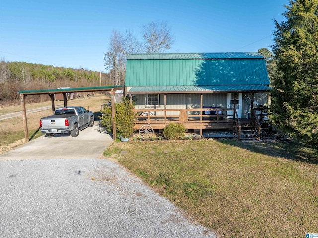 view of front facade with metal roof, a front yard, and driveway