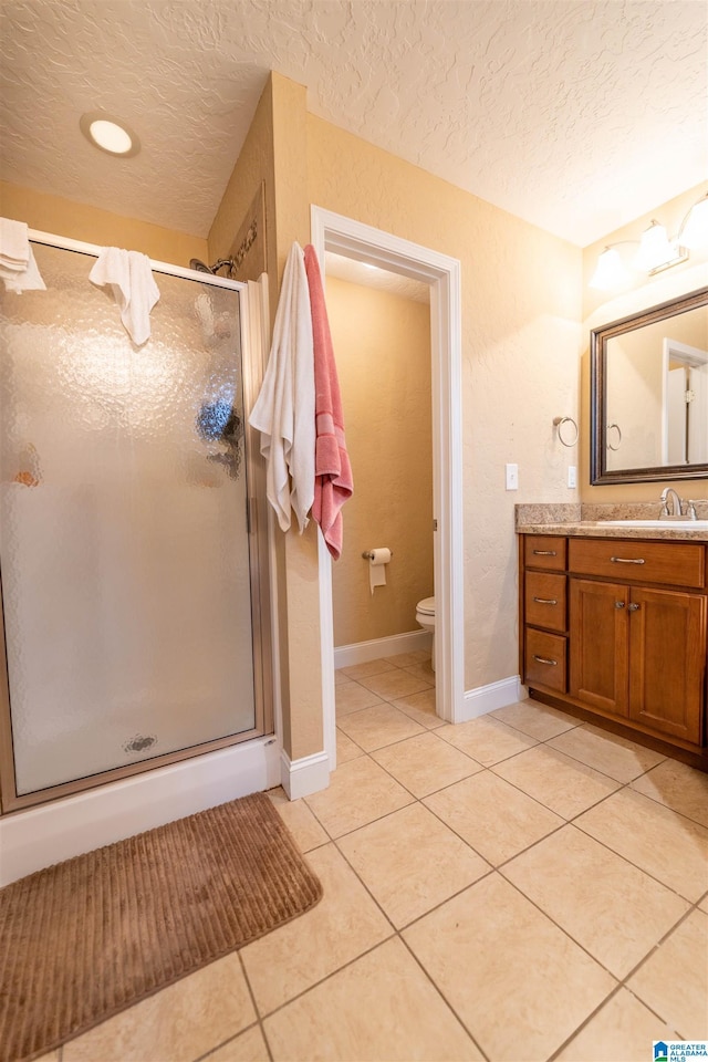 full bath featuring a shower stall, a textured ceiling, and tile patterned floors