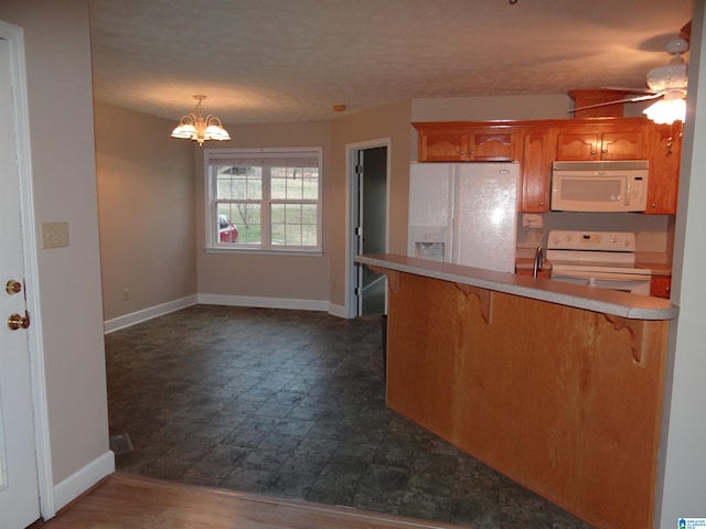 kitchen with a kitchen bar, light countertops, white appliances, a peninsula, and baseboards