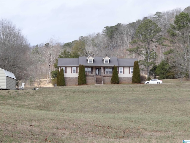 view of front of house with a porch, metal roof, and a front lawn