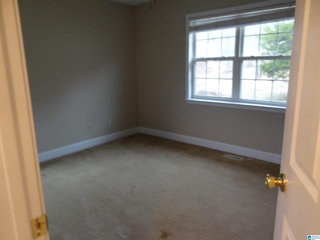 carpeted empty room with visible vents and baseboards