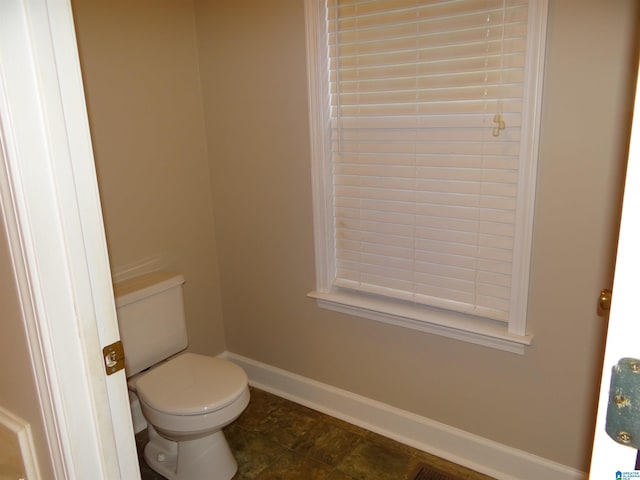 bathroom featuring toilet and baseboards