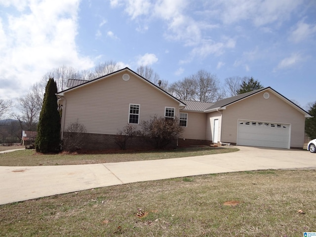 view of front facade with a garage, driveway, a front lawn, and metal roof