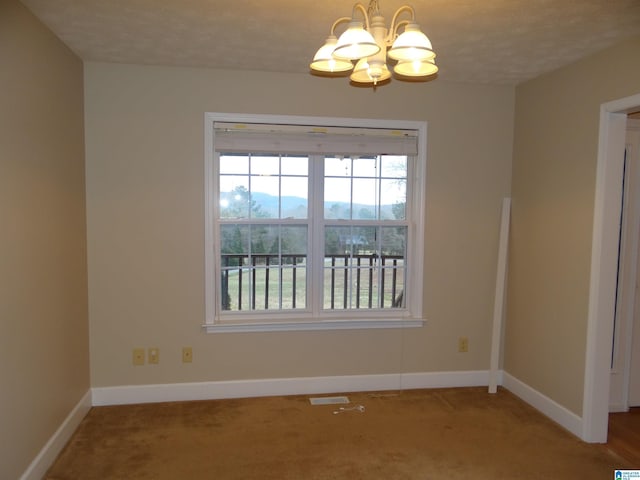 empty room with baseboards, visible vents, a notable chandelier, and light colored carpet