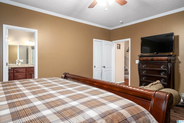 bedroom featuring ornamental molding, a textured ceiling, ensuite bathroom, and wood finished floors