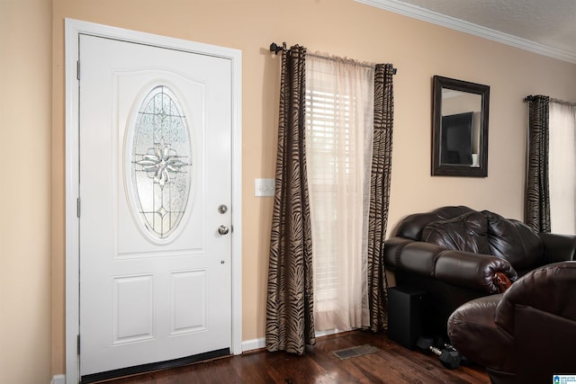 entryway with dark wood-style flooring, visible vents, and crown molding