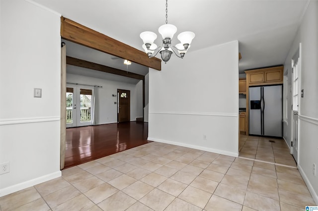 spare room with a chandelier, beamed ceiling, baseboards, and light tile patterned floors