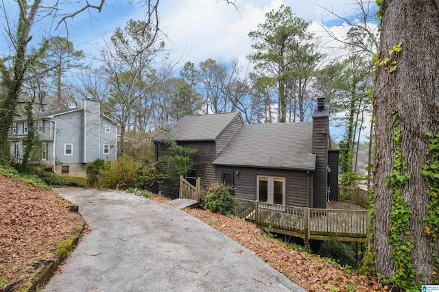 view of front of home with a chimney and a wooden deck