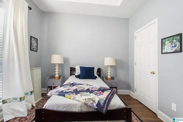 bedroom featuring dark wood finished floors and baseboards