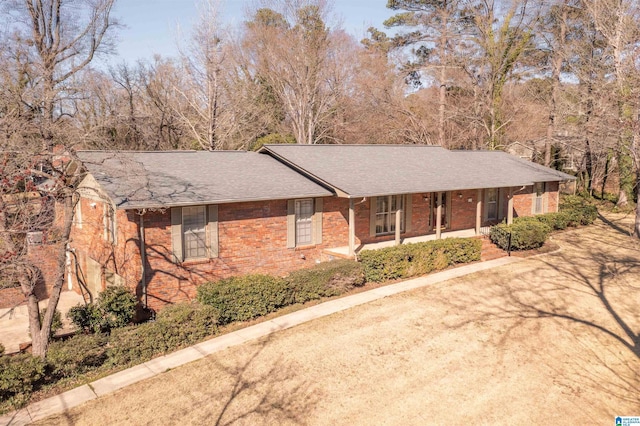 ranch-style home featuring brick siding and roof with shingles