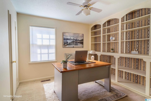 office area featuring baseboards, ceiling fan, visible vents, and a textured ceiling