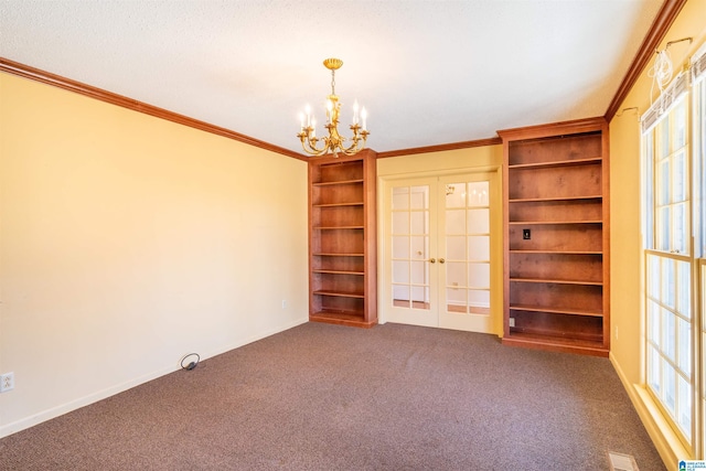 carpeted empty room with visible vents, a chandelier, crown molding, and french doors